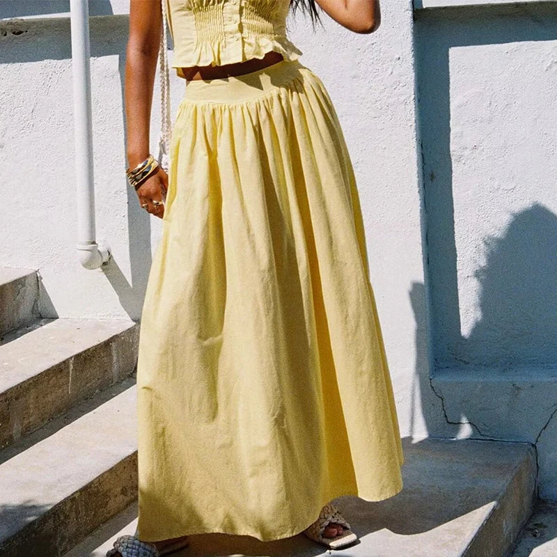 allvariant::Person wearing a yellow dress standing on steps with a white wall background