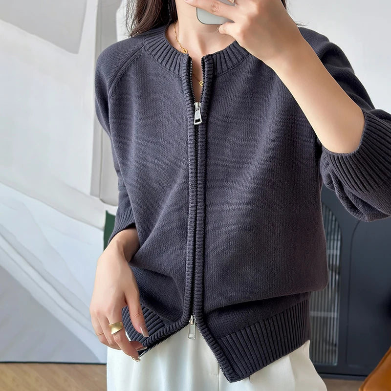 allvariants:: Person wearing a dark gray zip-up sweater indoors