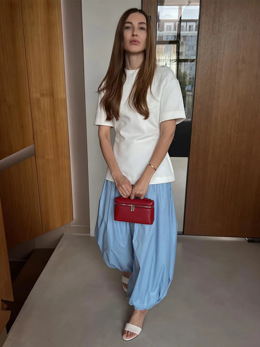 light blue::Woman holding a red handbag in an indoor setting