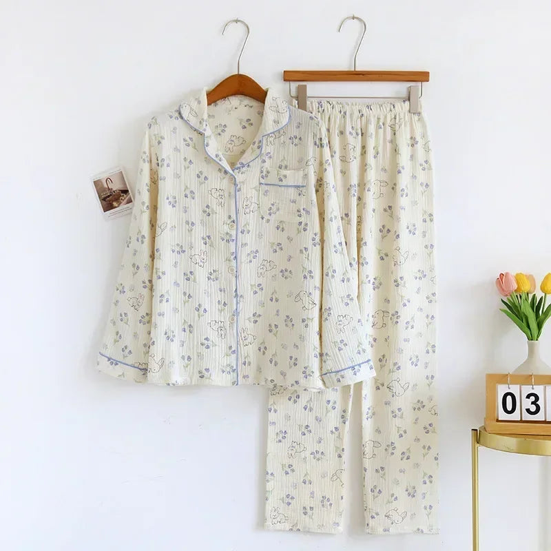 allvariants:: Floral pajama set hanging on a rack against a white wall with a small table and tulips in the background.