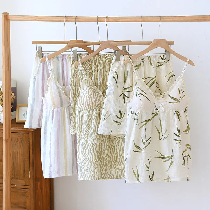 allvariants:: Four women's tops on hangers against a white wall with wooden furniture.