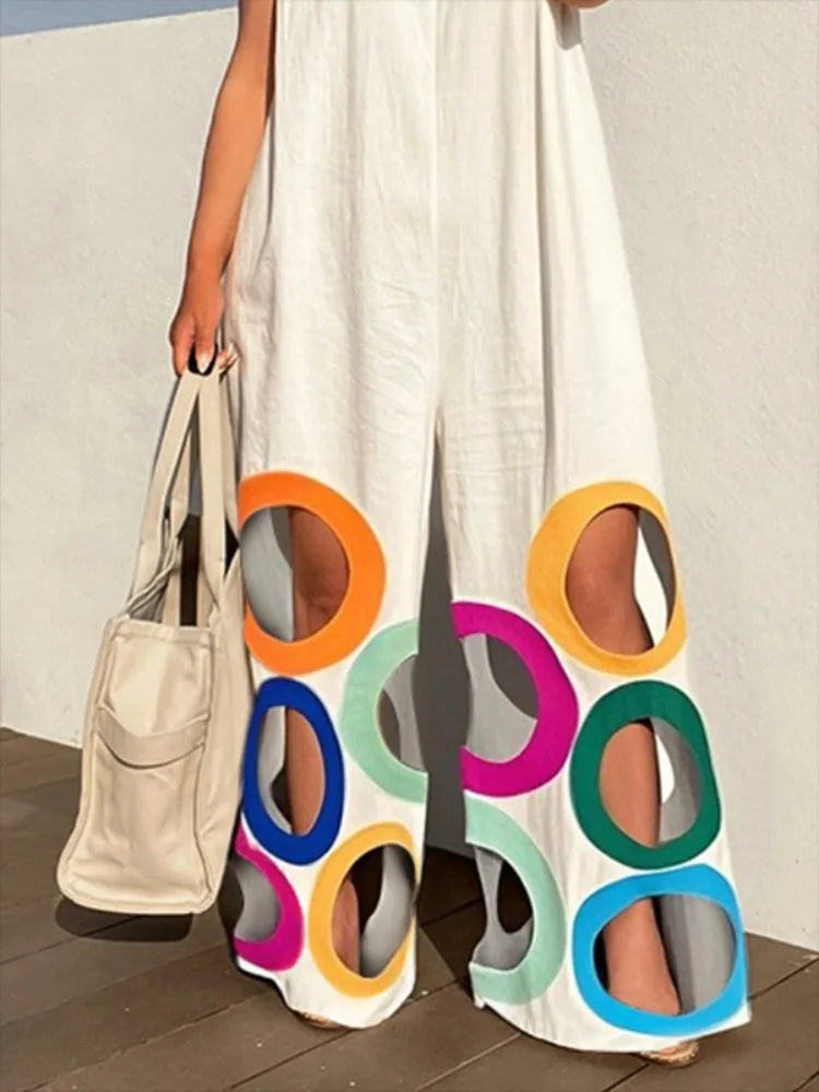 white::Person holding a beige tote bag and colorful circular sandals on a wooden floor.