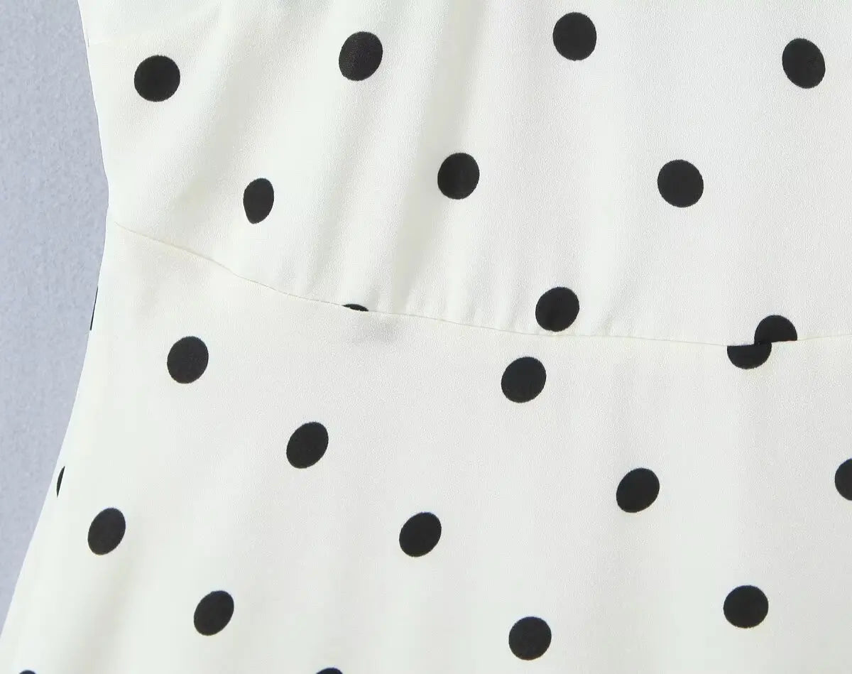 White::White dress with black polka dots on a light gray background