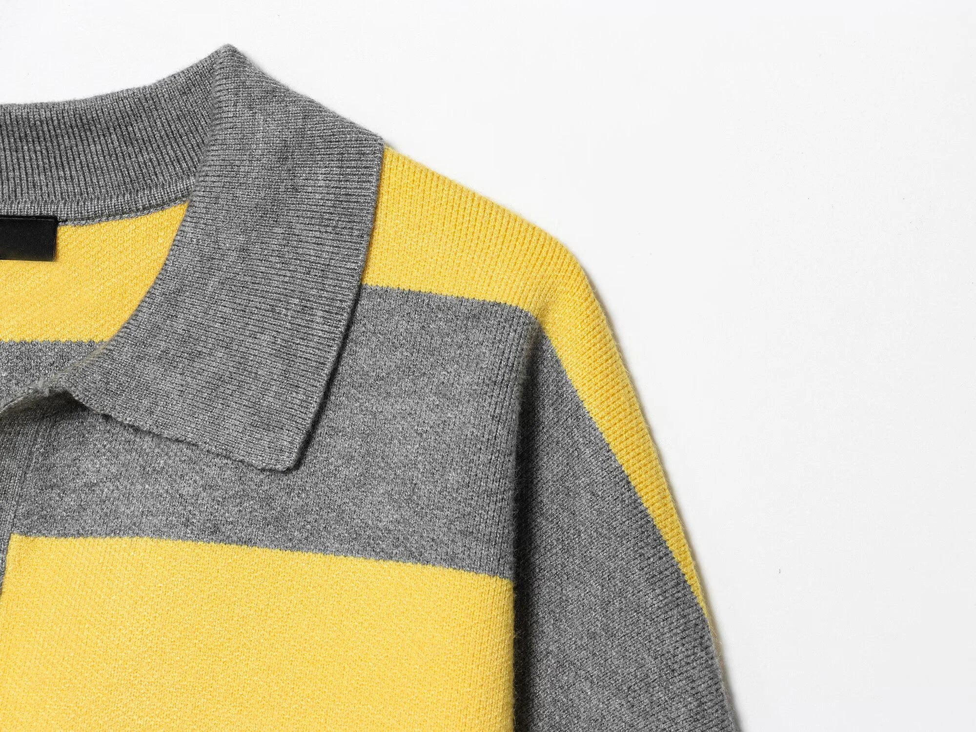 stripped::Close-up of a gray and yellow striped sweater with a collar on a white background