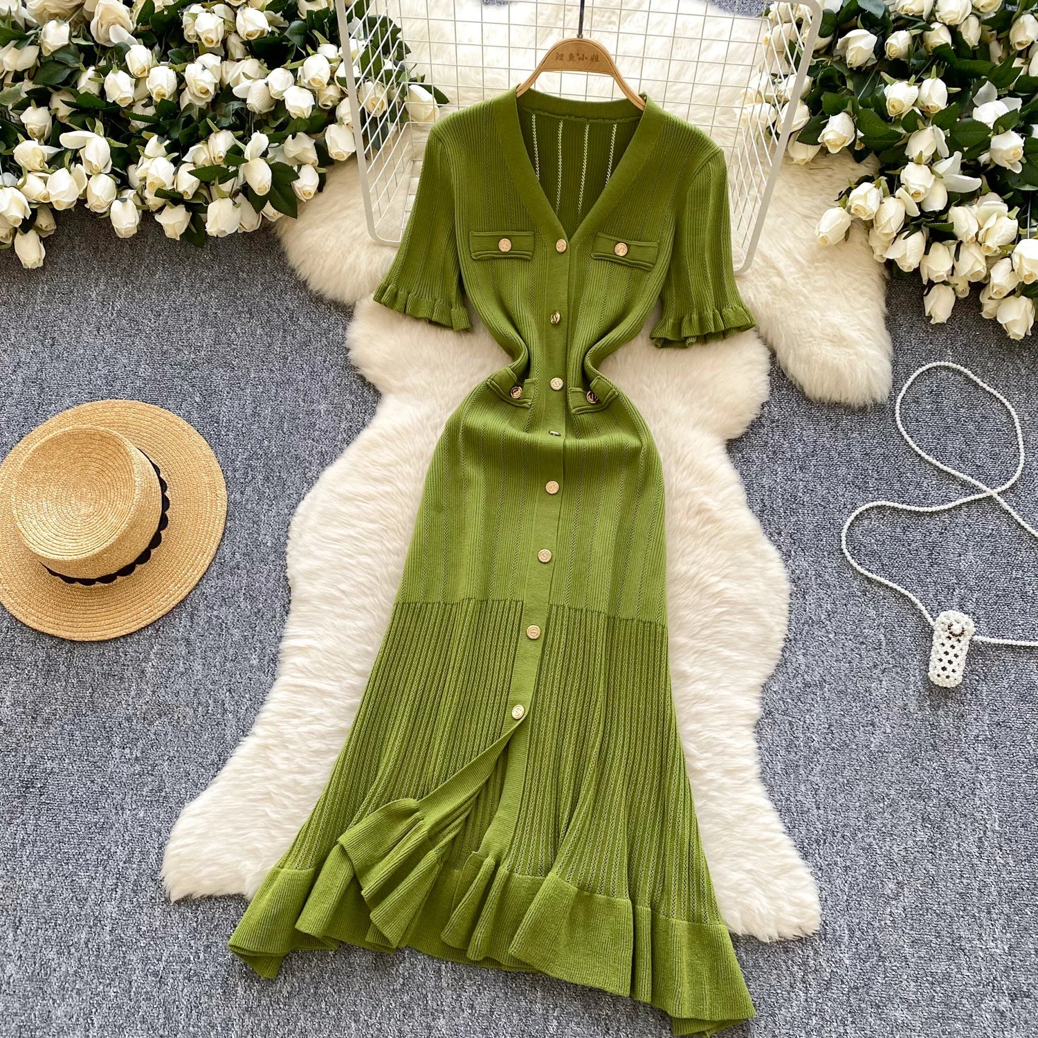 allvariants:: Green dress on a hanger with decorative elements on a textured surface