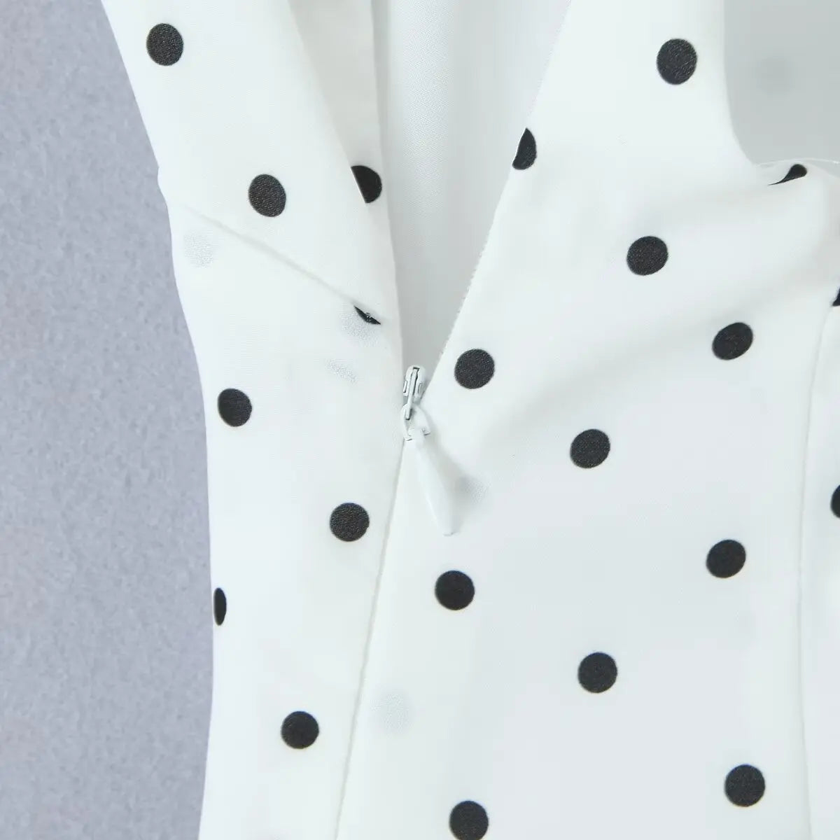 white::White fabric with black polka dots on a gray background
