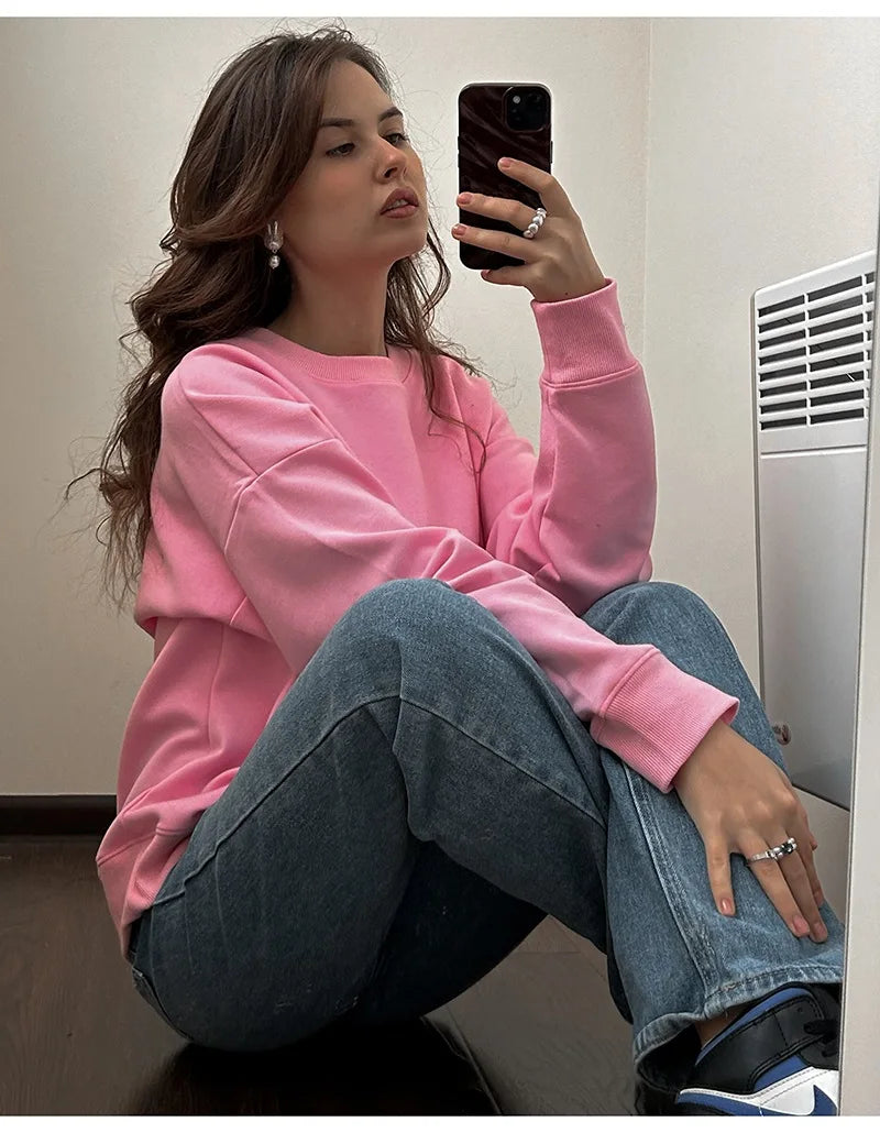 allvariants:: Person wearing a pink sweatshirt and blue jeans sitting on the floor.