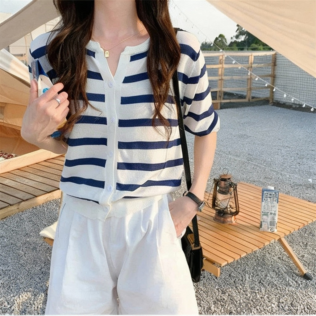 allvariants:: Person wearing a blue and white striped shirt and white pants outdoors.