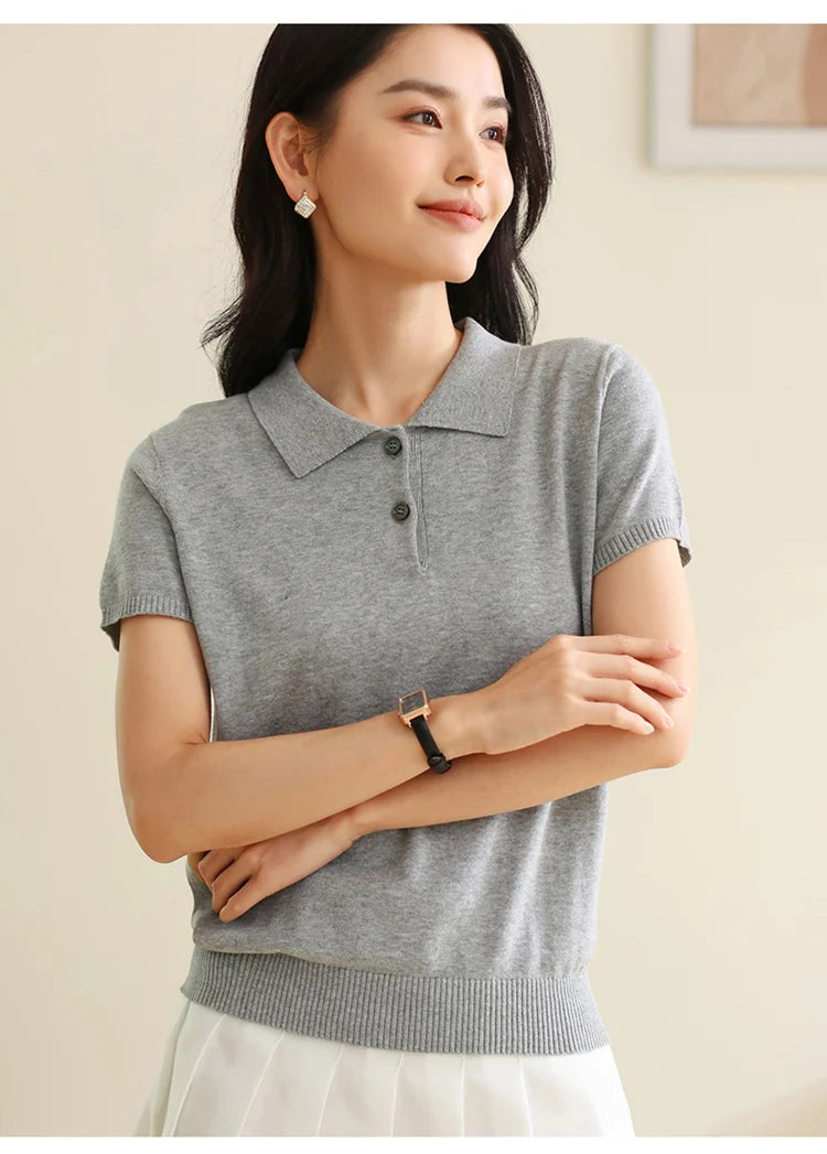 Light Grey:: Woman wearing a gray short-sleeve knit polo shirt with a plain background