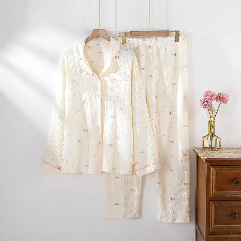 allvariants:: Butterfly-patterned pajama set hanging on a rack against a white wall with a wooden dresser and pink flowers in the background.