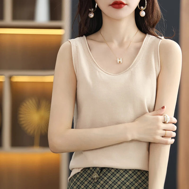 allvariants:: Woman wearing a beige sleeveless top with a blurred indoor background