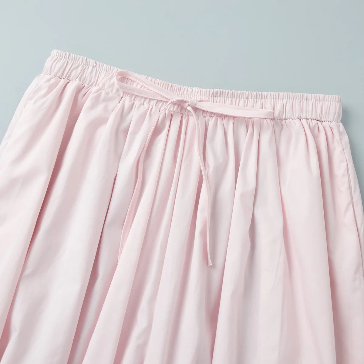 pink::Close-up of a light pink skirt with an elastic waistband on a light gray background