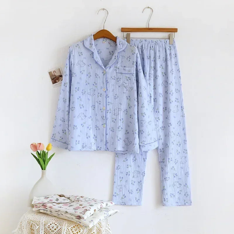 allvariants:: Light blue pajama set with floral pattern on hangers against a white wall.