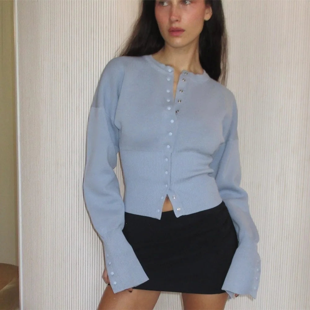 blue::Woman wearing a light blue button-up shirt and black skirt against a neutral background