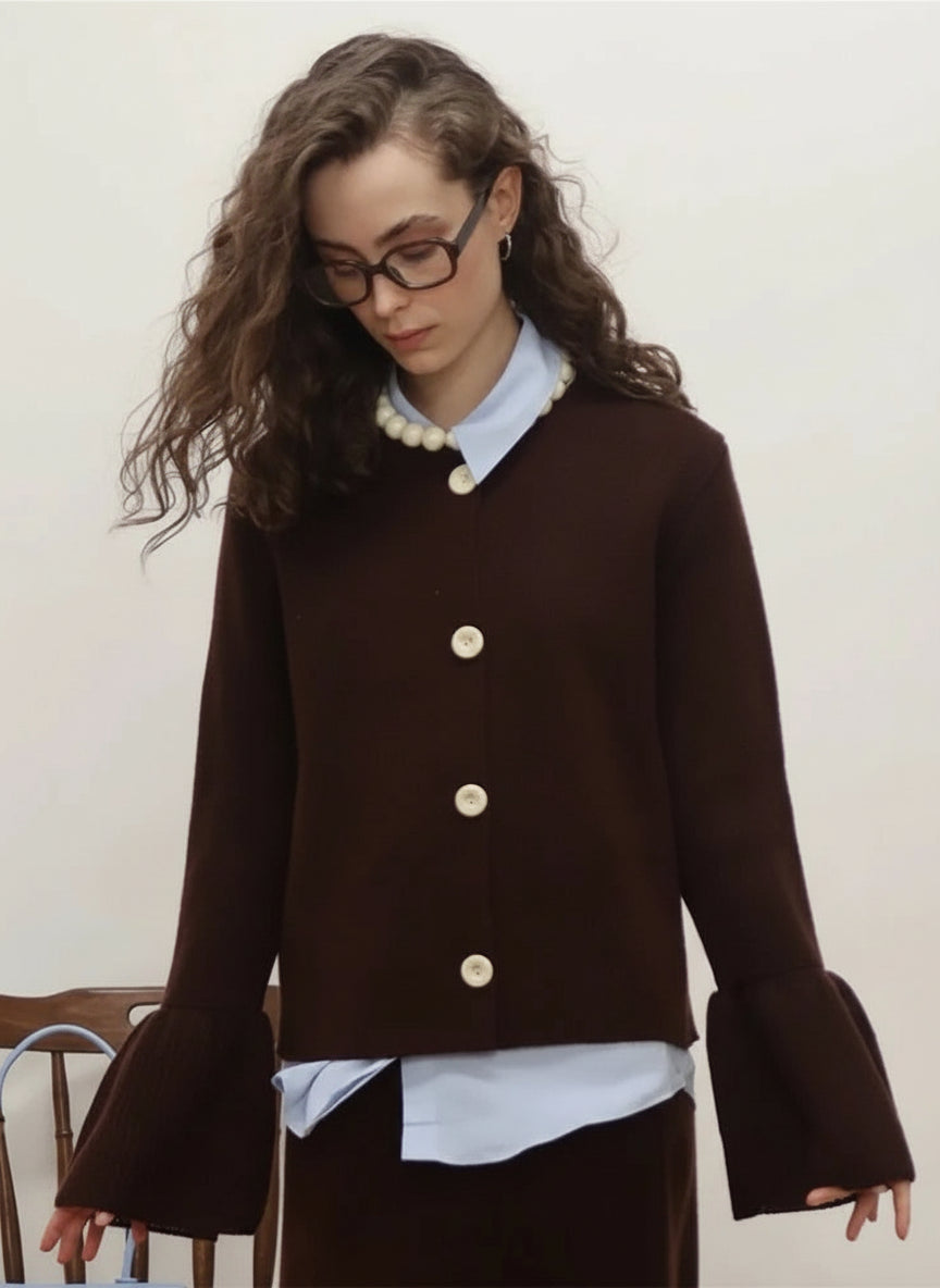 allvariants:: Woman wearing a brown jacket with white buttons against a plain background