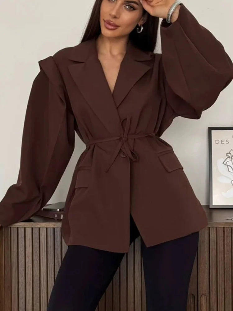 allvariants:: Woman wearing a brown blazer in an indoor setting