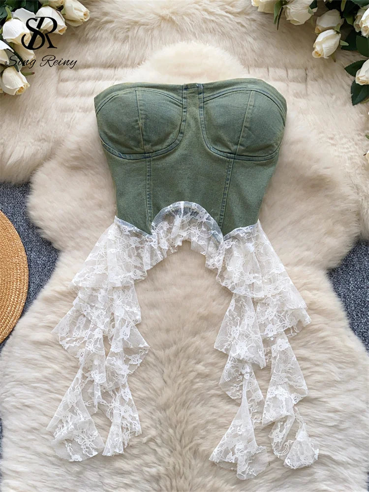 Green strapless top with lace details on a fluffy white surface.