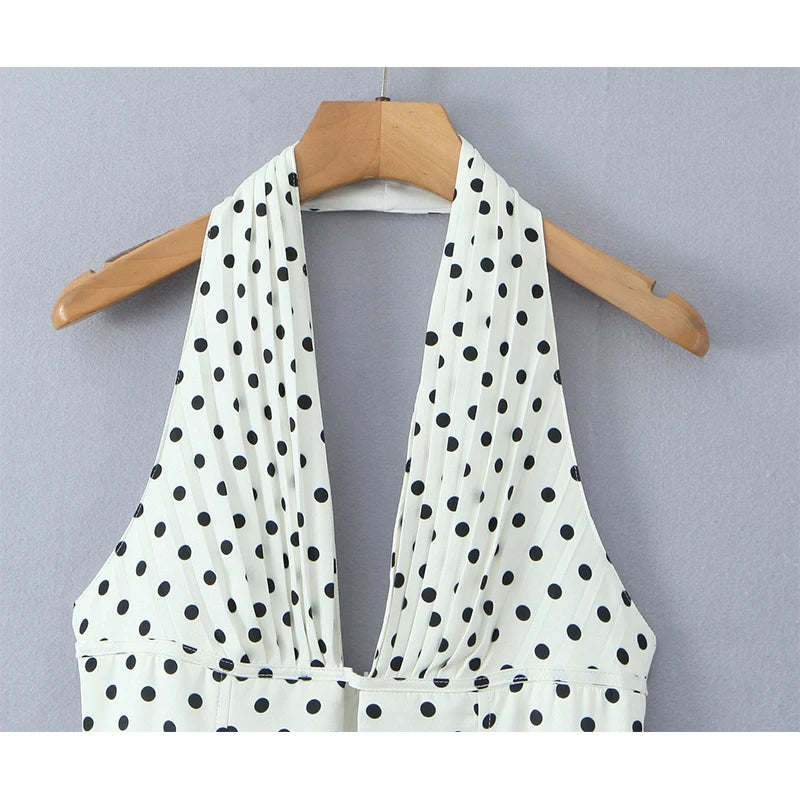 white::White polka dot halter top on a wooden hanger against a gray background