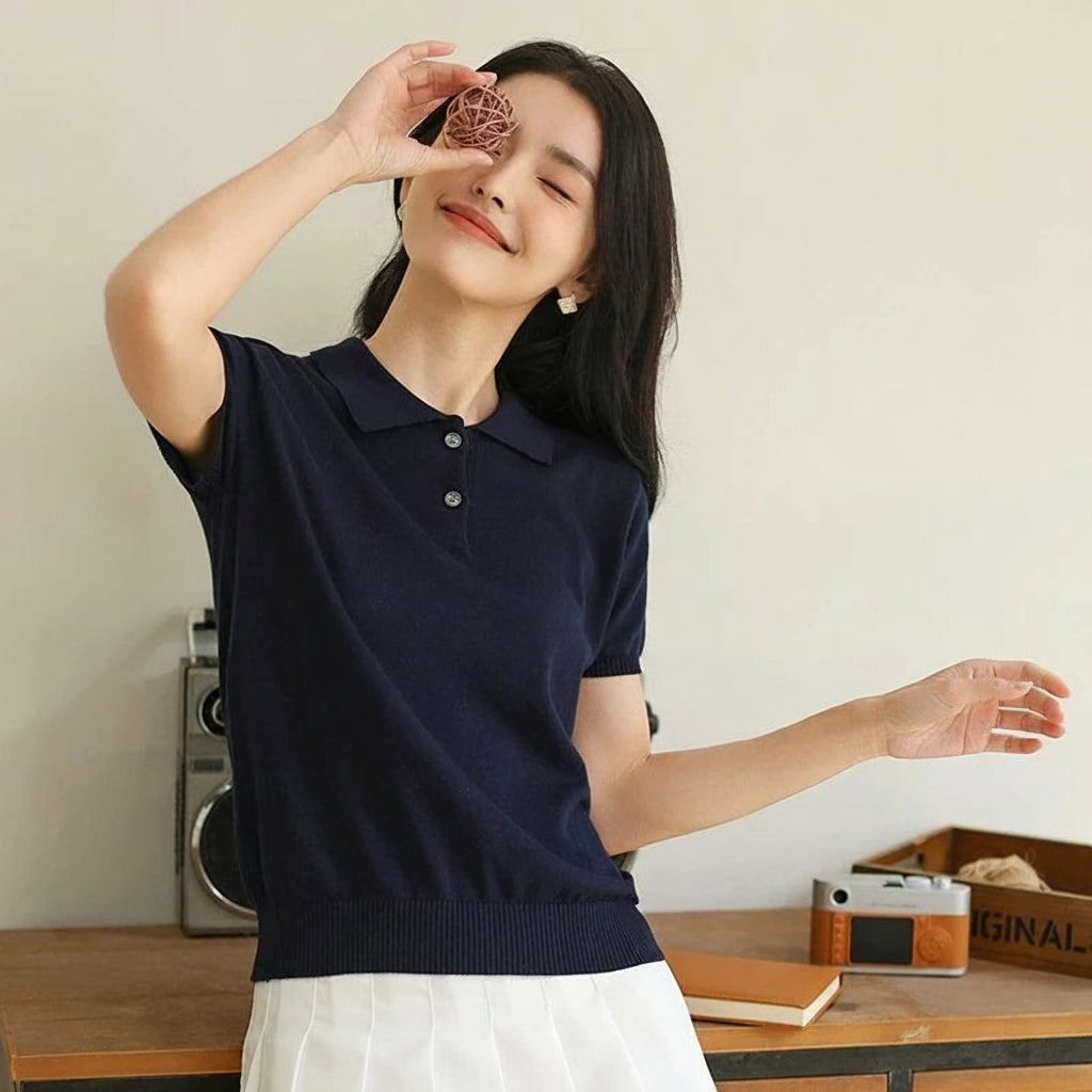 Dark Blue:: Woman wearing a navy blue polo shirt with a minimal background