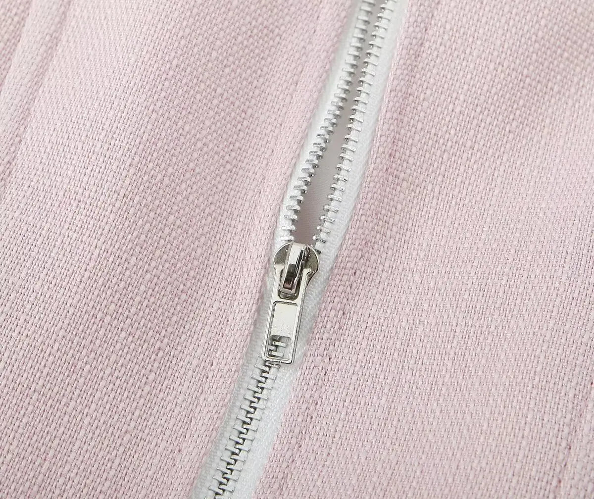 pink::Close-up of a silver zipper on pink fabric