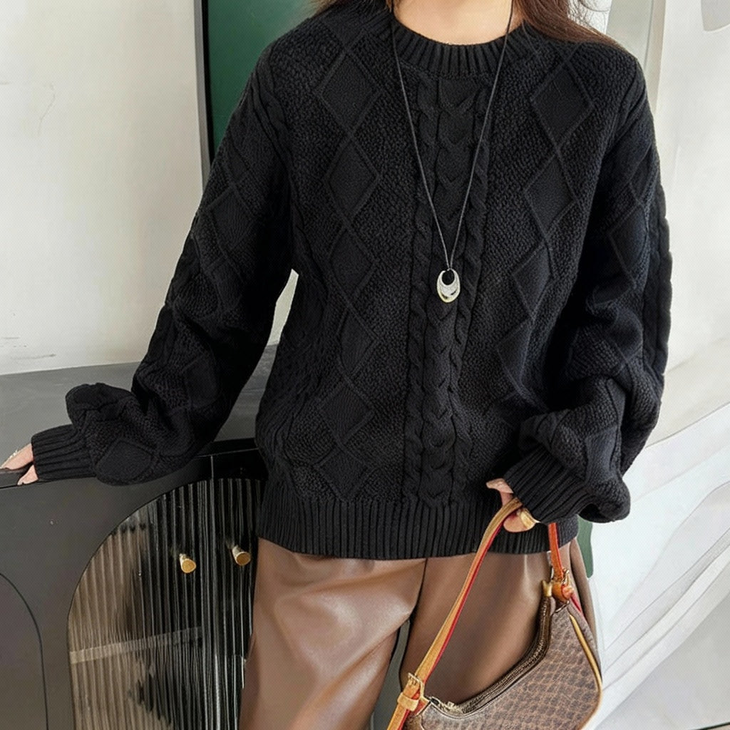 Black:: Person wearing a black cable knit sweater with a visible brand logo, holding a handbag.