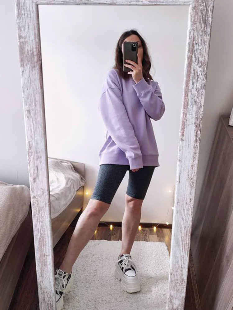 allvariants:: Person wearing a purple sweatshirt and black shorts taking a mirror selfie.