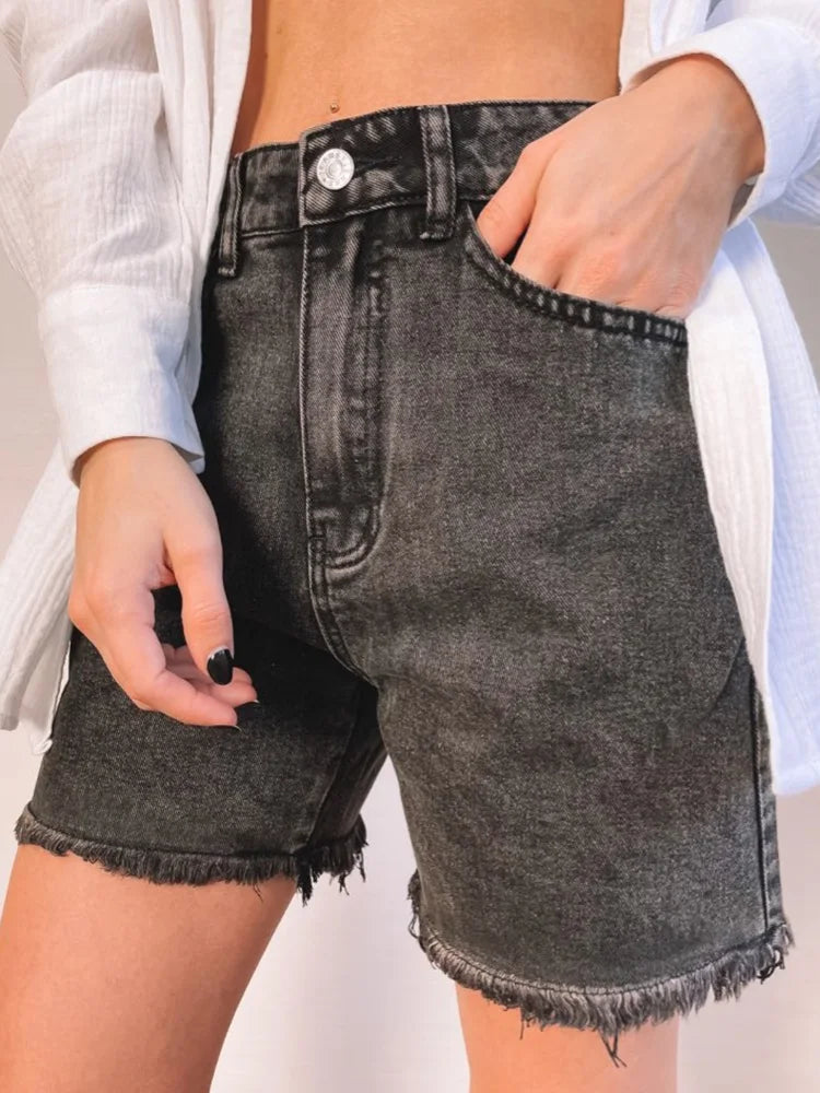 Black:: Person wearing black denim shorts with a white shirt.