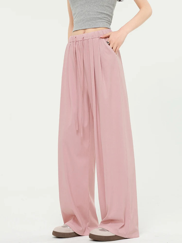 allvariants:: Person wearing pink wide-leg pants and a gray top on a white background