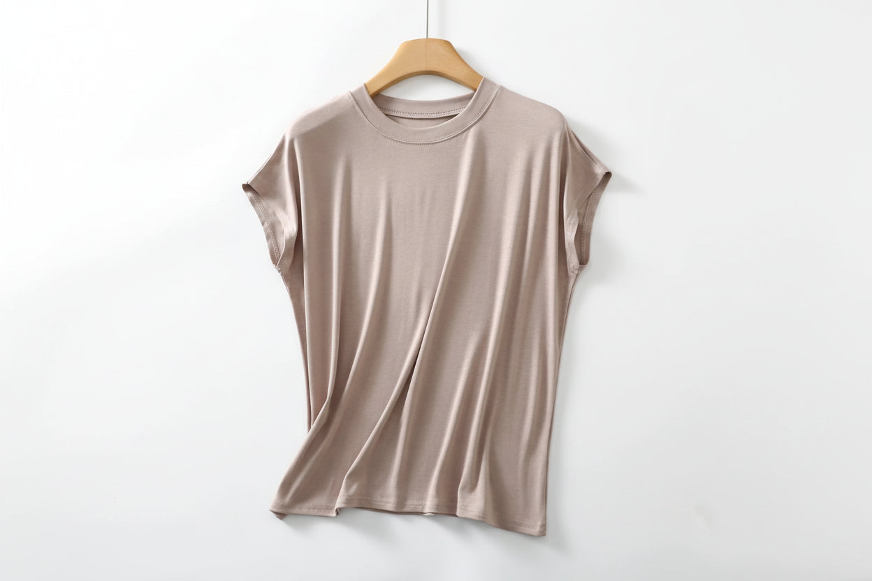 allvariants:: Beige t-shirt on a wooden hanger against a white background