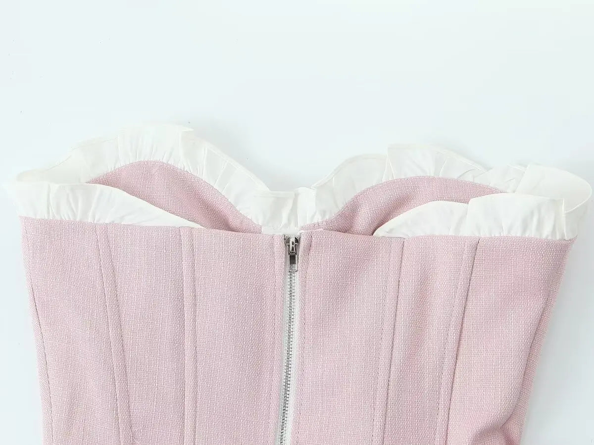 pink::Close-up of a pink garment with white trim on a light gray background
