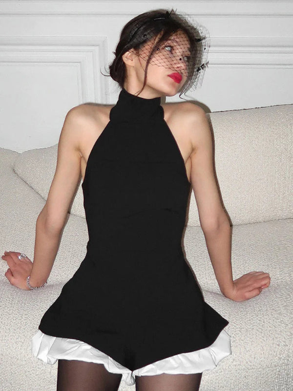 black:: Woman wearing a black halter top dress with white underskirt on a neutral background