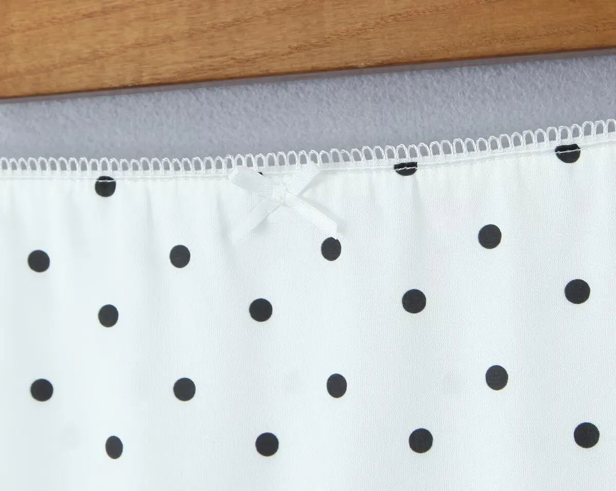 white::White fabric with black polka dots on a gray background
