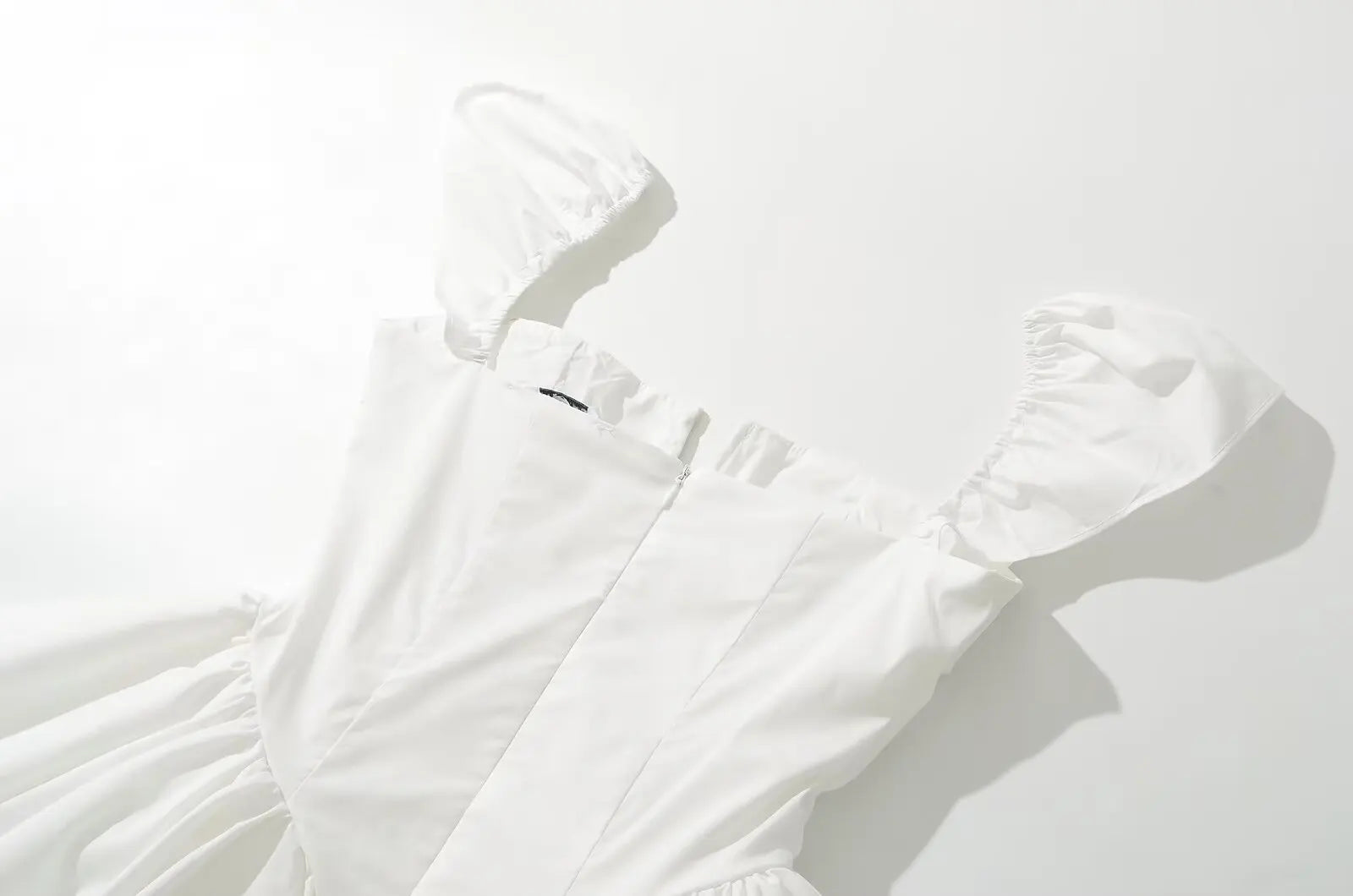 white::White dress on a hanger against a white background