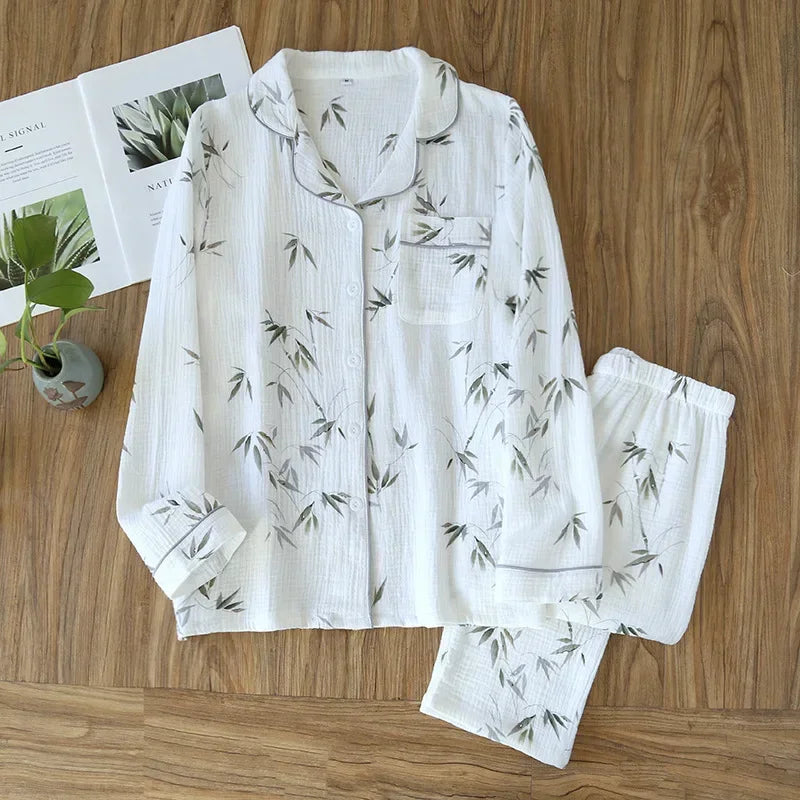 allvariants:: White pajama set with green leaf pattern on a wooden surface with magazines and a plant.