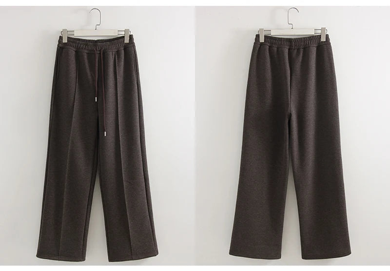 allvariants:: Pair of brown pants on hangers against a white background