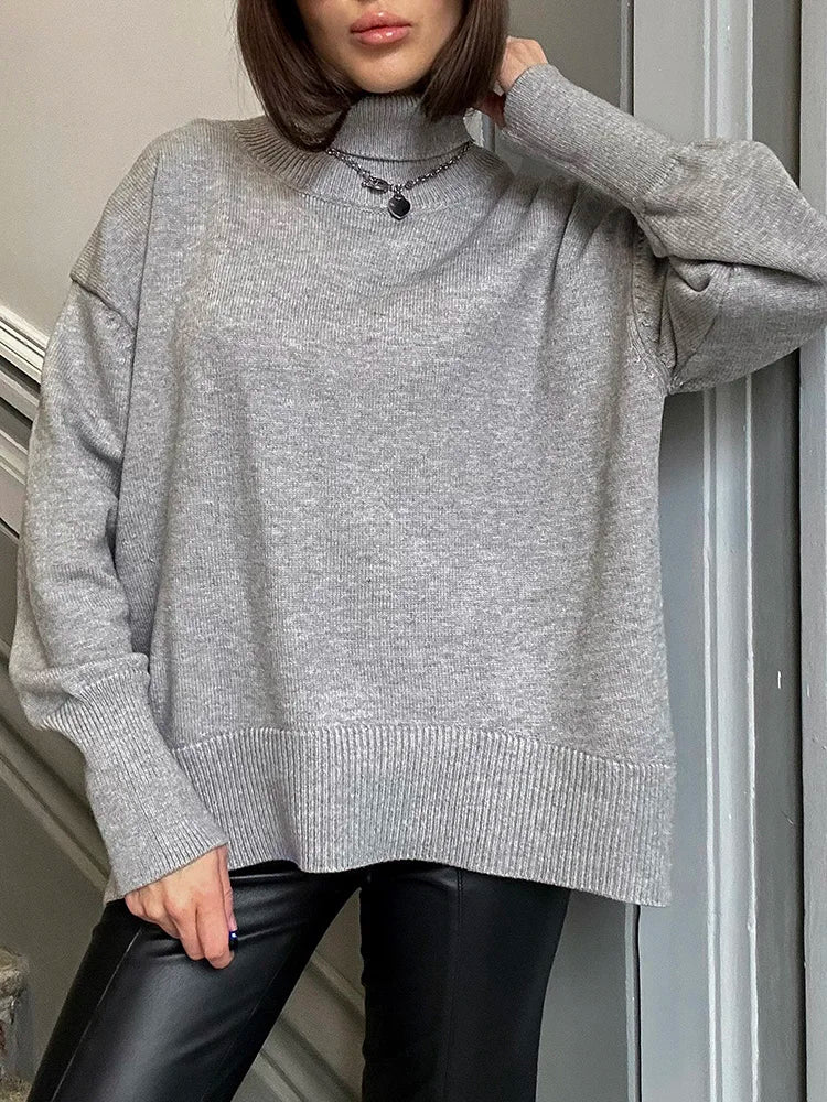 allvariants:: Person wearing a gray sweater and black pants indoors.