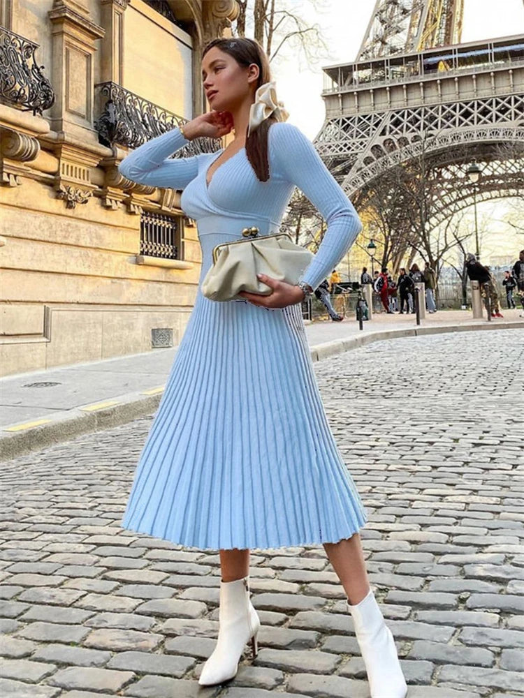 allvariants:: Woman in a light blue dress standing in front of the Eiffel Tower.