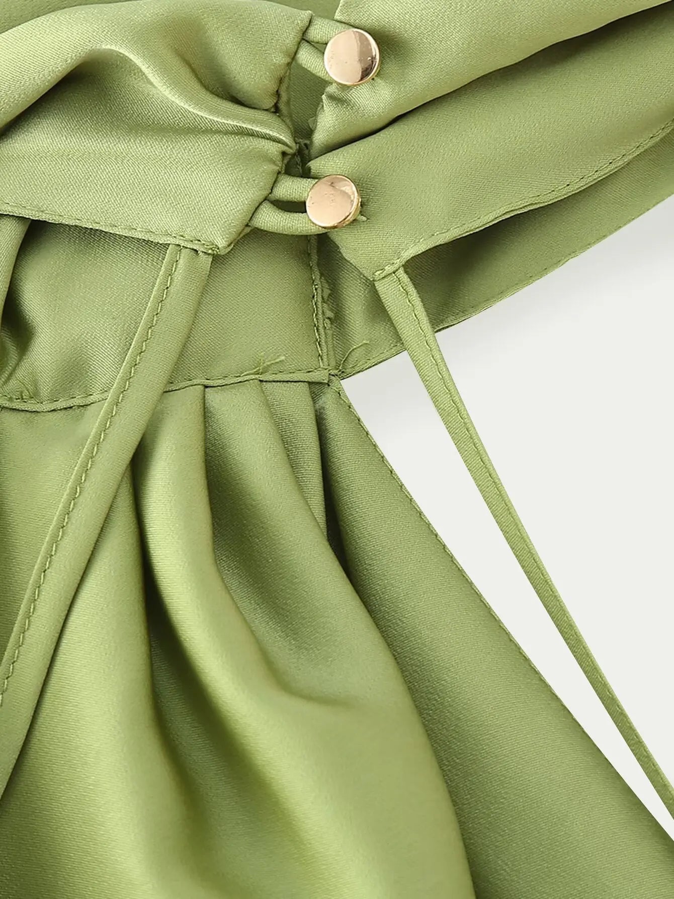 Green::Close-up of a green fabric with buttons on a white background