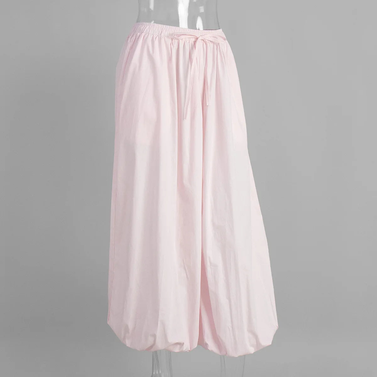 pink::Light pink wide-leg pants on a mannequin against a gray background