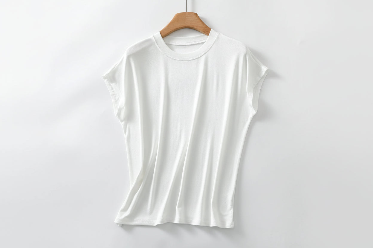 allvariants:: White t-shirt on a wooden hanger against a light gray background