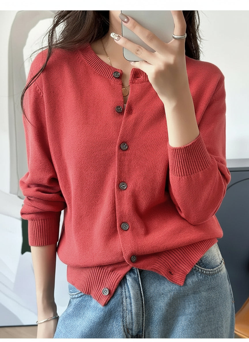 Red:: Person wearing a red cardigan and blue jeans, taking a mirror selfie.