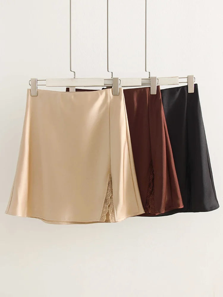allvariants:: Three satin skirts in gold, brown, and black hanging on a rack against a white background.