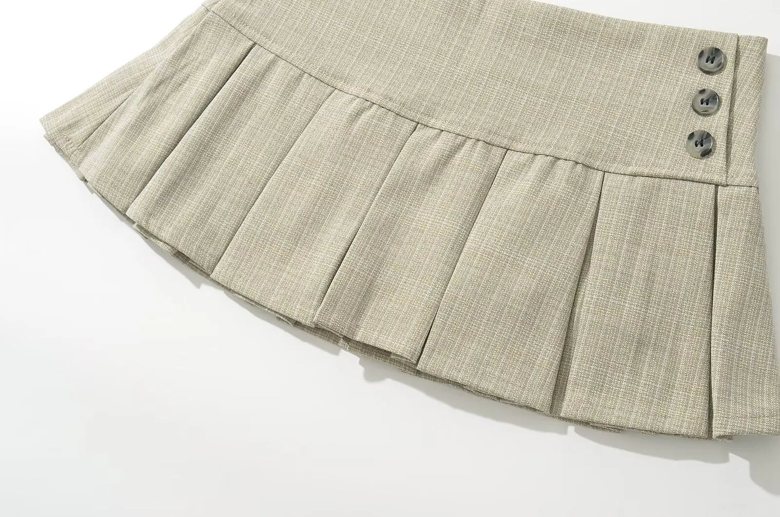 beige::Beige pleated skirt with button details on a white background