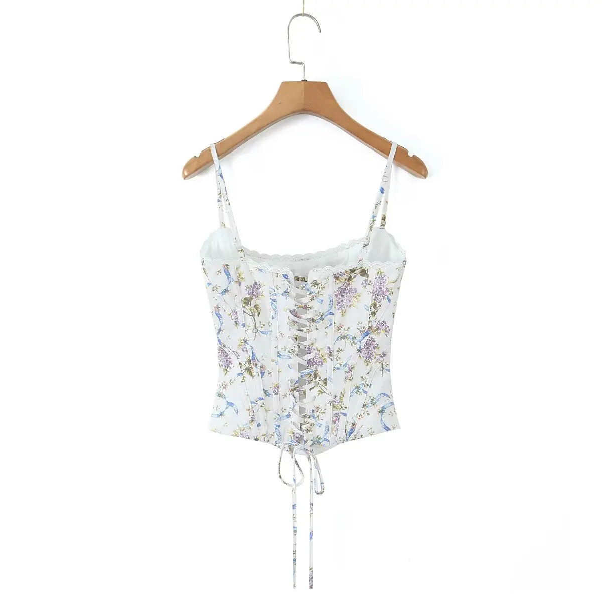 white::floral crop top on a wooden hanger against a white background