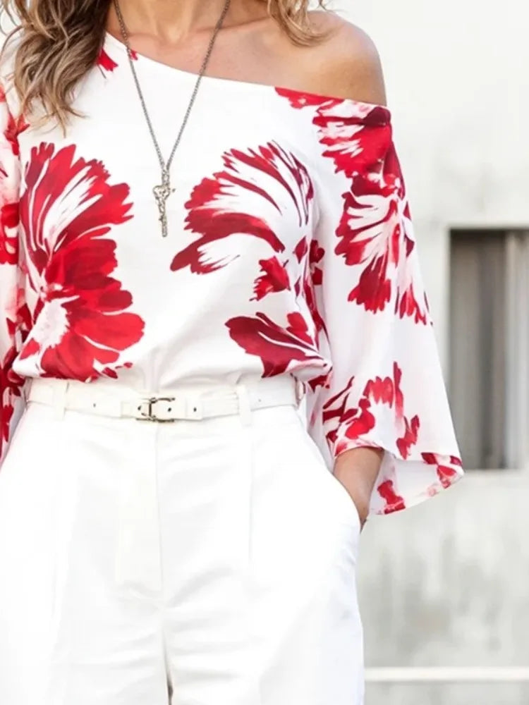 allvariant::Woman wearing a white off-shoulder top with red floral patterns and white pants.