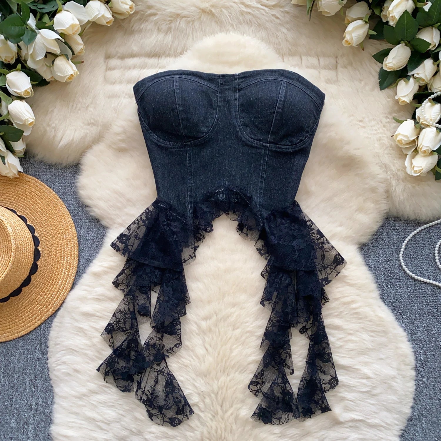 allvariants:: Navy blue lace babydoll top on a fluffy white surface with flowers and a hat.