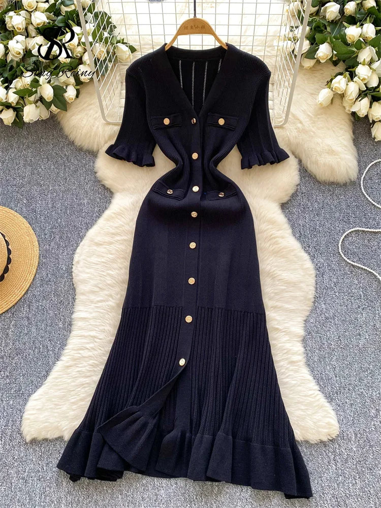 allvariants:: Navy blue dress with ruffled details on a textured surface with decorative elements.