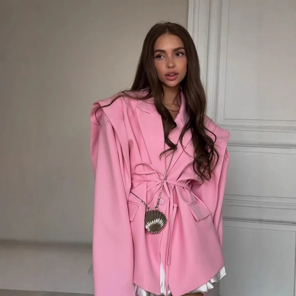 allvariants:: Woman wearing a pink coat in a minimal indoor setting