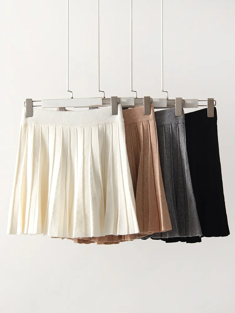 allvariants:: Three skirts in white, brown, and black hanging on a rack against a white background