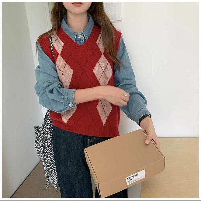 Red:: Person wearing a red argyle sweater vest over a blue shirt, holding a cardboard box.